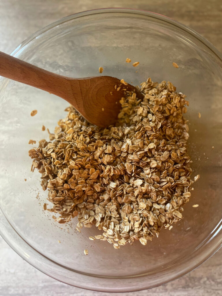 unbaked granola being stirred with a spoon