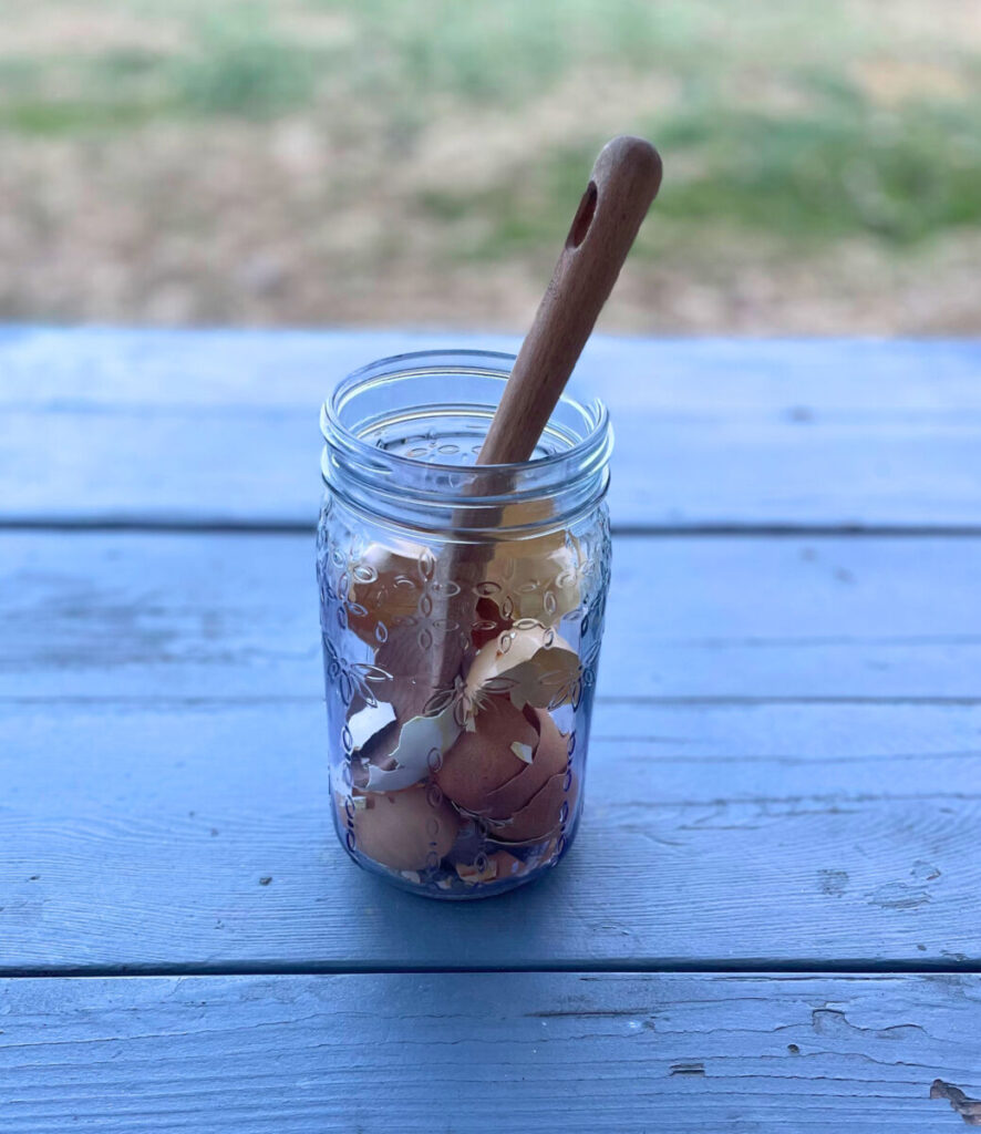broken eggshells in a glass jar with a wooden spoon