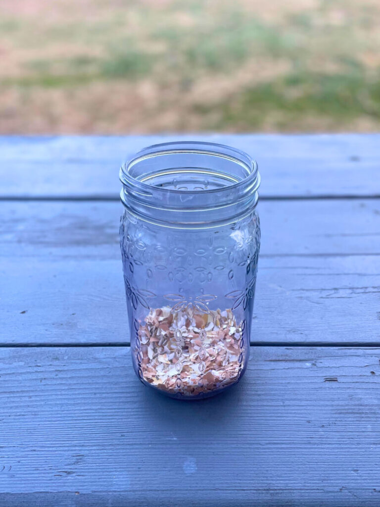 crushed eggshells in the bottom of a glass jar