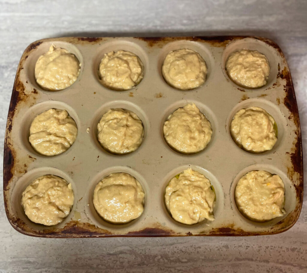 raw muffin batter spooned into stone muffin tin