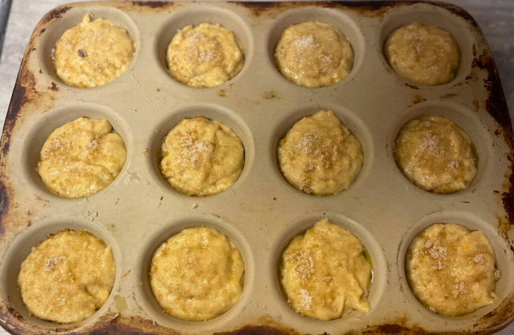 raw muffin batter sprinkled with brown sugar and sugar mixture