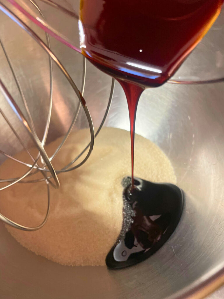molasses being poured into bowl of sugar