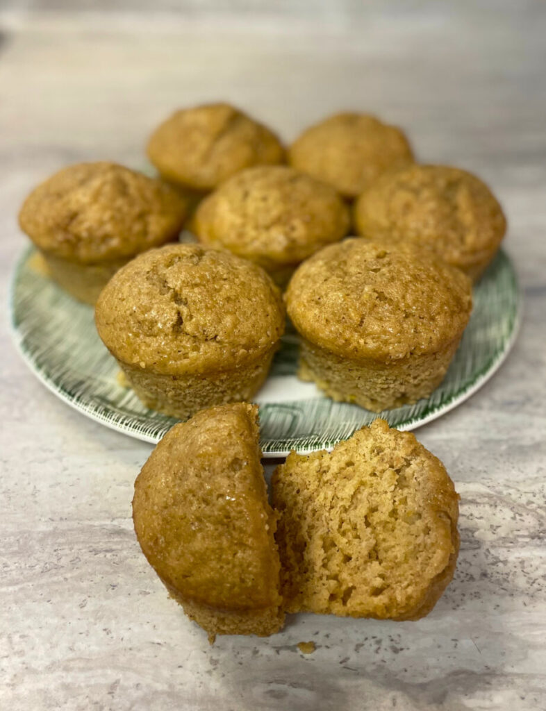 muffin cut in half in front of a plate of muffins