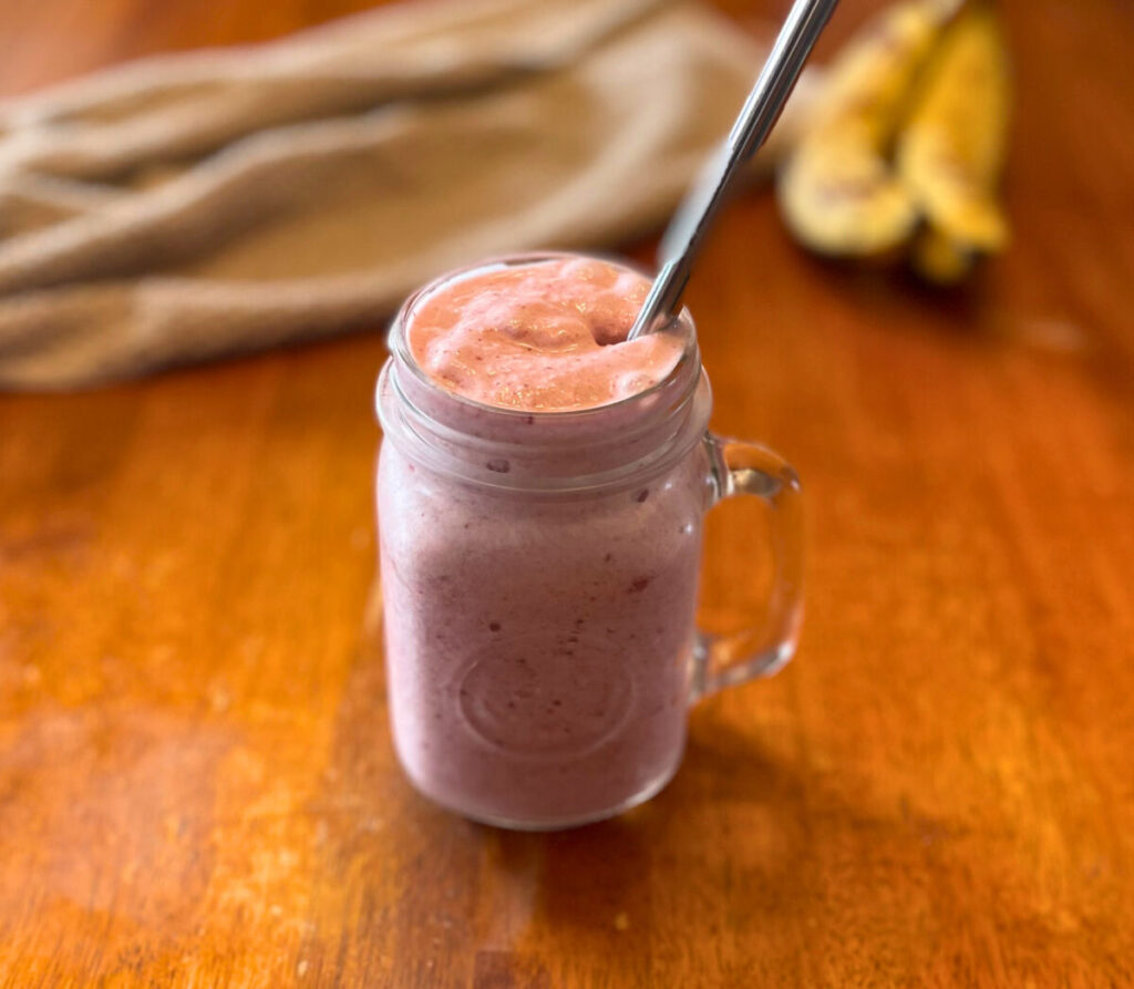 pink smoothie in glass drinking jar with straw