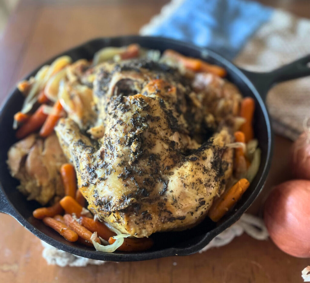 cooked whole chicken in a cast iron skillet