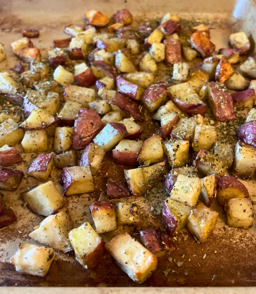diced and roasted red potatoes on a baking stone
