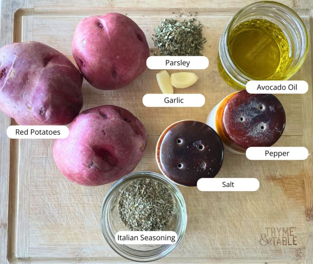 ingredients for oven-fried red potatoes laid out on a cutting board